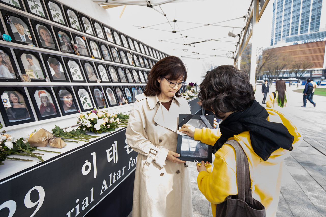 이옥수씨의 딸이자 이태원 참사 희생자 박현진씨의 영정을 최순화씨가 닦아주고 있다. ⓒ김흥구