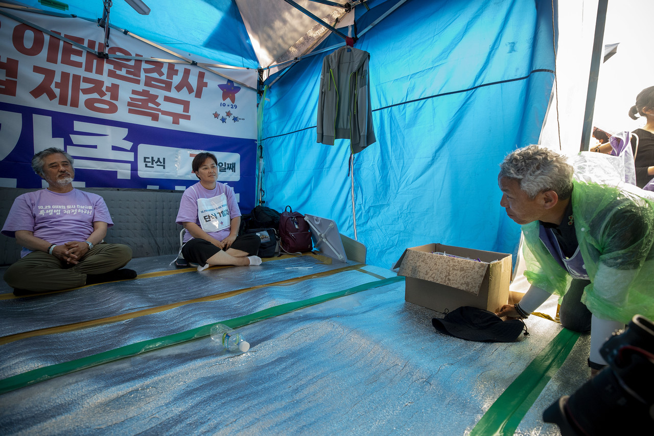 단식 중인 이정민 유가협 대표 직무대행(맨 왼쪽)과 최선미 운영위원(왼쪽)이 행진을 마치고 온 송진영 직무대행(오른쪽)과 인사를 나누고 있다. ⓒ시사IN 박미소