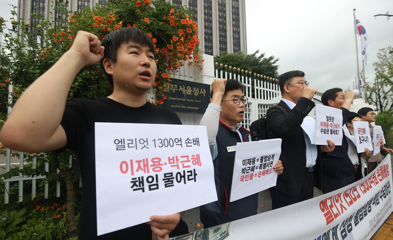 6월26일 오전, 서울 종로구 정부서울청사 앞에서 참여연대 등 5개 단체가 연 '엘리엇 1300억원 배상에 따른 국고 지출 이재용·박근혜 책임 추궁 촉구 기자회견'에서 참가자들이 국고 손실을 회수할 방안 마련을 촉구하며 구호를 외치고 있다. ⓒ연합뉴스