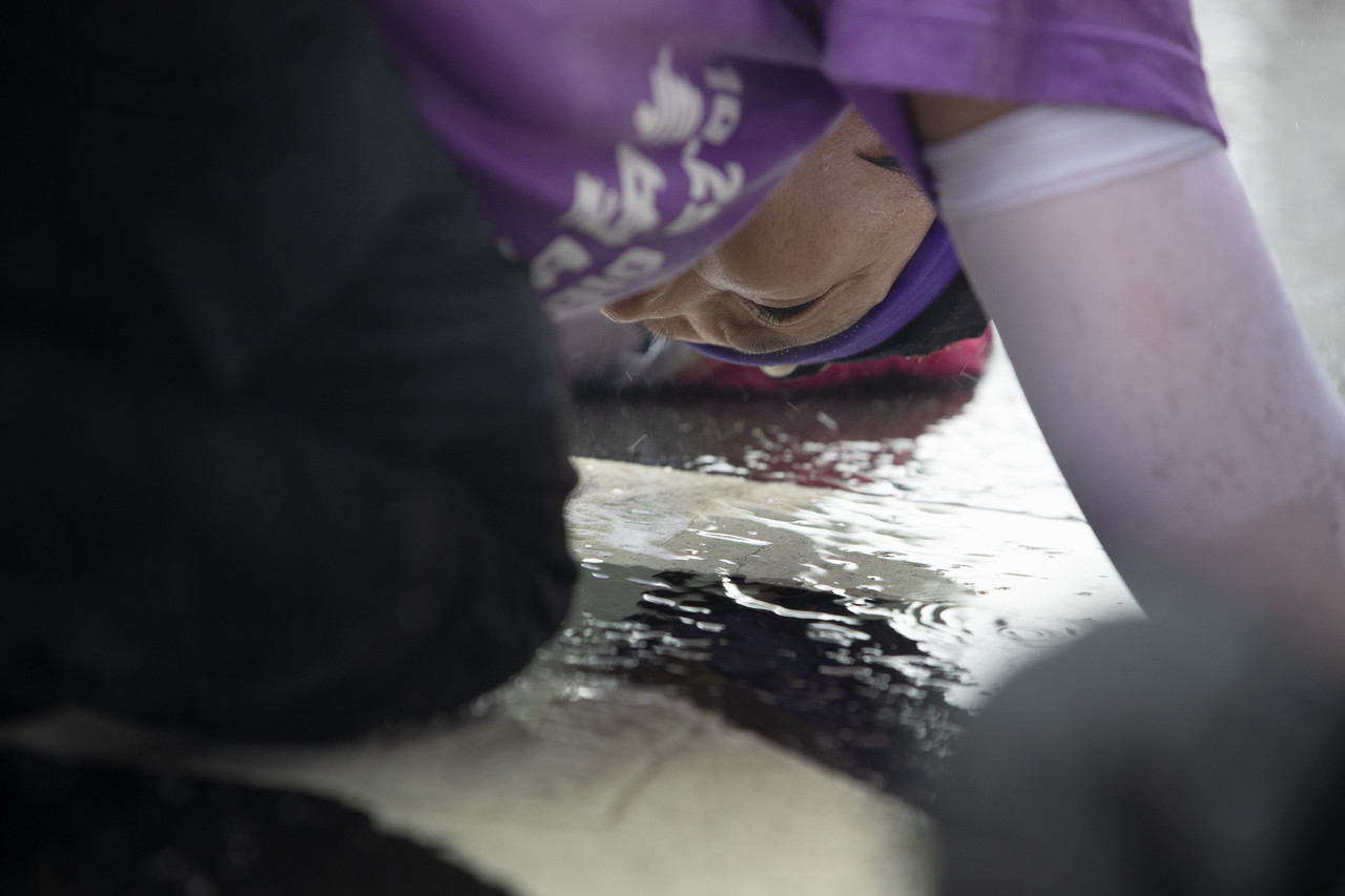 이태원 참사 희생자 이남훈씨(1994년생)의 어머니 박영수씨(57)의 이마가 빗물이 고인 바닥에 닿는다. 박씨는 지난 300일을 