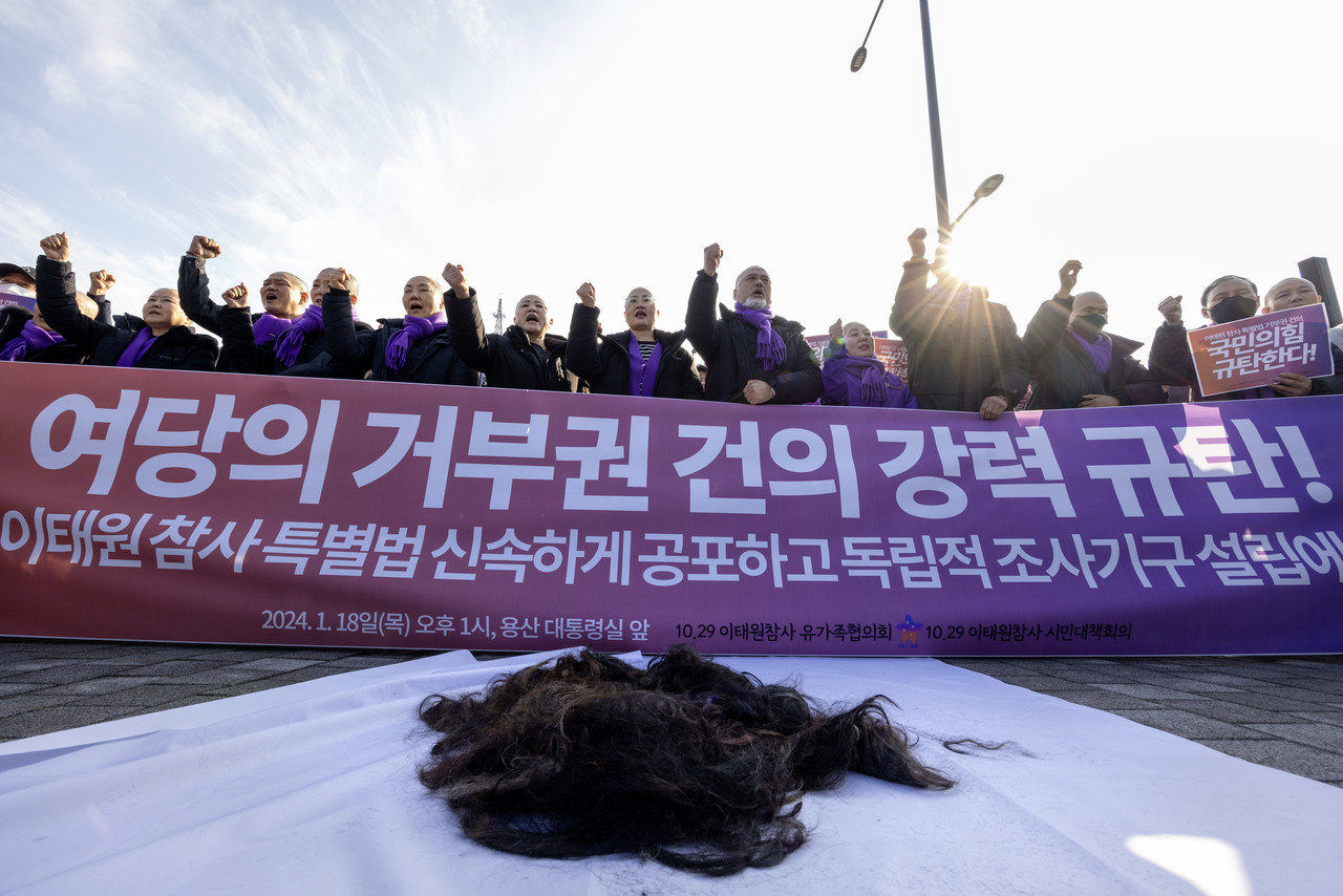 삭발을 마친 유족들이 잘린 머리카락을 앞에 두고 서서 윤석열 대통령의 이태원 특별법 공포를 촉구하며 구호를 외치고 있다. ⓒ시사IN 조남진
