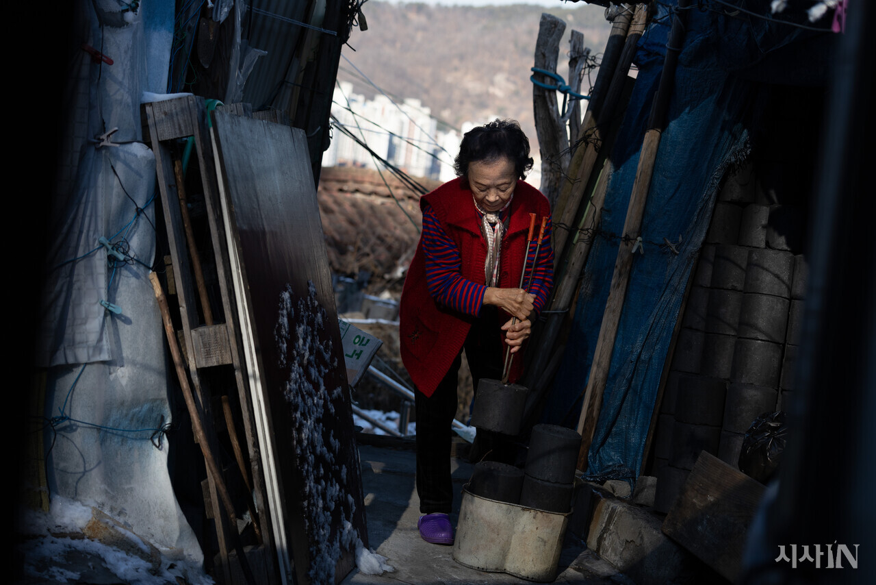 성탄절을 하루 앞둔 2024년 12월24일 오전 서울 서대문구 홍제동 개미마을에서 50년간 살아온 박상기 할머니(83)가 부엌에서 쓸 연탄을 나르고 있다. ⓒ시사IN 이명익