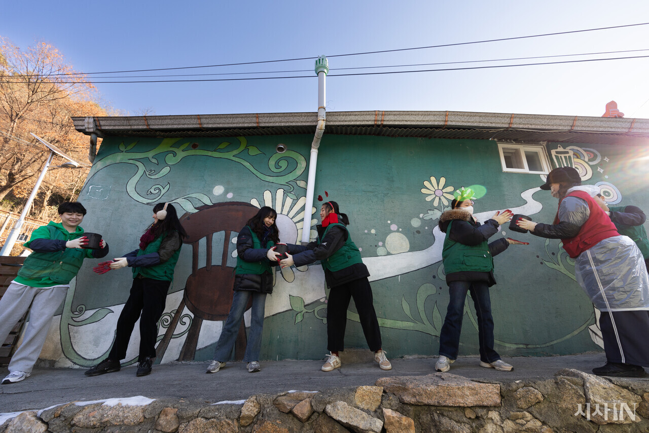 2024년 12월24일 서울 서대문구 홍제동 개미마을에서 연탄은행 주최로 열린 ‘성탄 연탄데이’ 연탄나눔 행사에서 자원봉사자들이 손에서 손으로 연탄을 나르고 있다. ⓒ시사IN 이명익