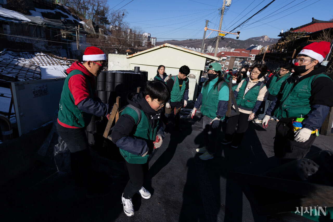 2024년 12월24일 서울 서대문구 홍제동 개미마을에서 연탄은행 주최로 열린 ‘성탄 연탄데이’ 연탄나눔 행사에 참여한 박윤우 학생(12)이 연탄 지게를 지고 있다. ⓒ시사IN 이명익