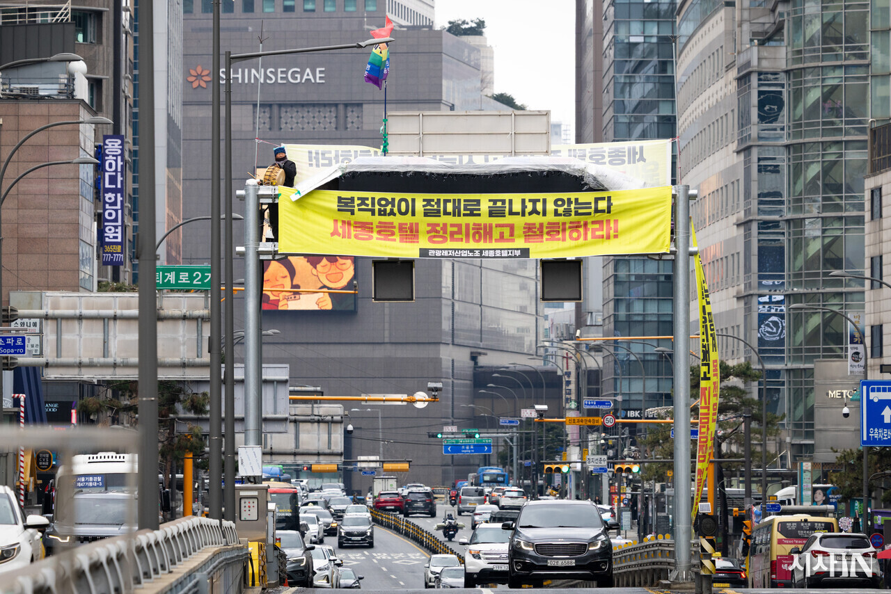 3월18일 고공 농성 34일째를 맞은 고진수 관광레저산업노조 세종호텔지부 지부장이 서울 명동 세종호텔 앞 지하차도 철제 구조물 위에 서 있다. ⓒ시사IN 신선영