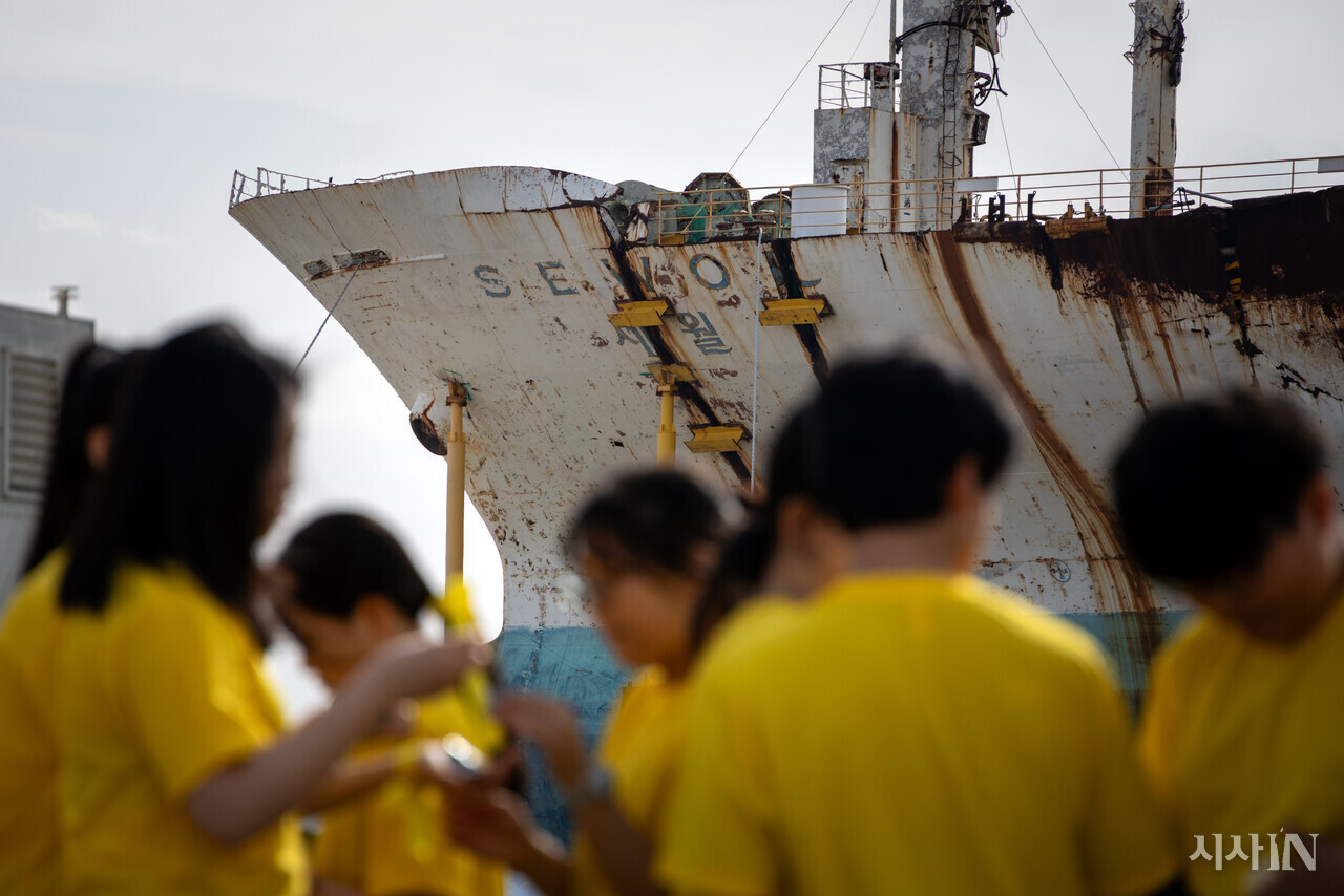 4월16일 오후 전남 목포신항에서 열린 기억식에 참석한 초등학생들 뒤로 세월호 선체가 거치되어 있다. ⓒ시사IN 신선영
