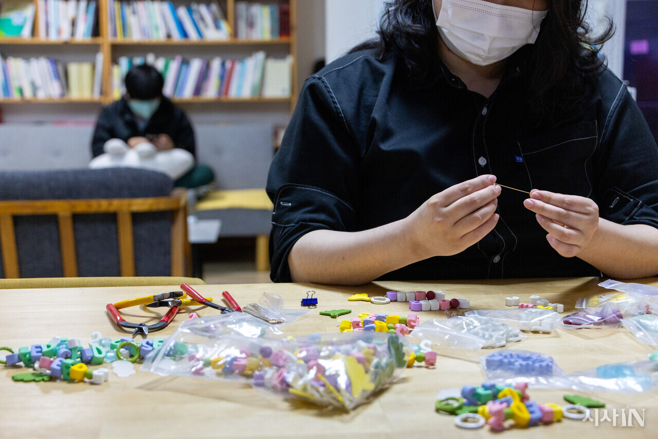 이미영씨(오른쪽)가 열쇠고리를 만드는 동안 한 청년(왼쪽)이 ‘두더집’ 거실에서 쉬고 있다. ⓒ시사IN 신선영