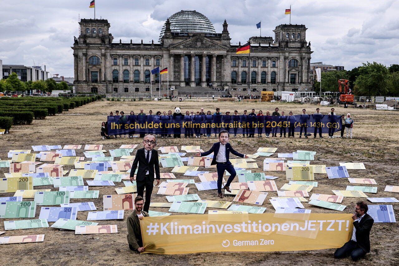 6월24일 환경운동가들이 독일 베를린 국회의사당 앞에서 메르츠 총리 마스크(왼쪽)를 쓰고 독일 정부의 기후 보호 정책 후퇴를 비판하고 있다. ⓒEPA