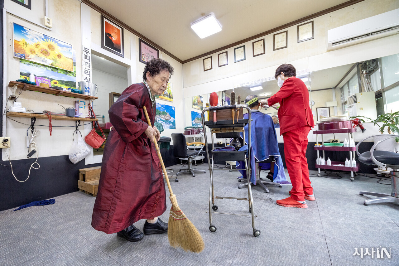 각시 미용실에서 손님이 직접 빗자루로 바닥을 쓸고 있다. ⓒ시사IN 박미소