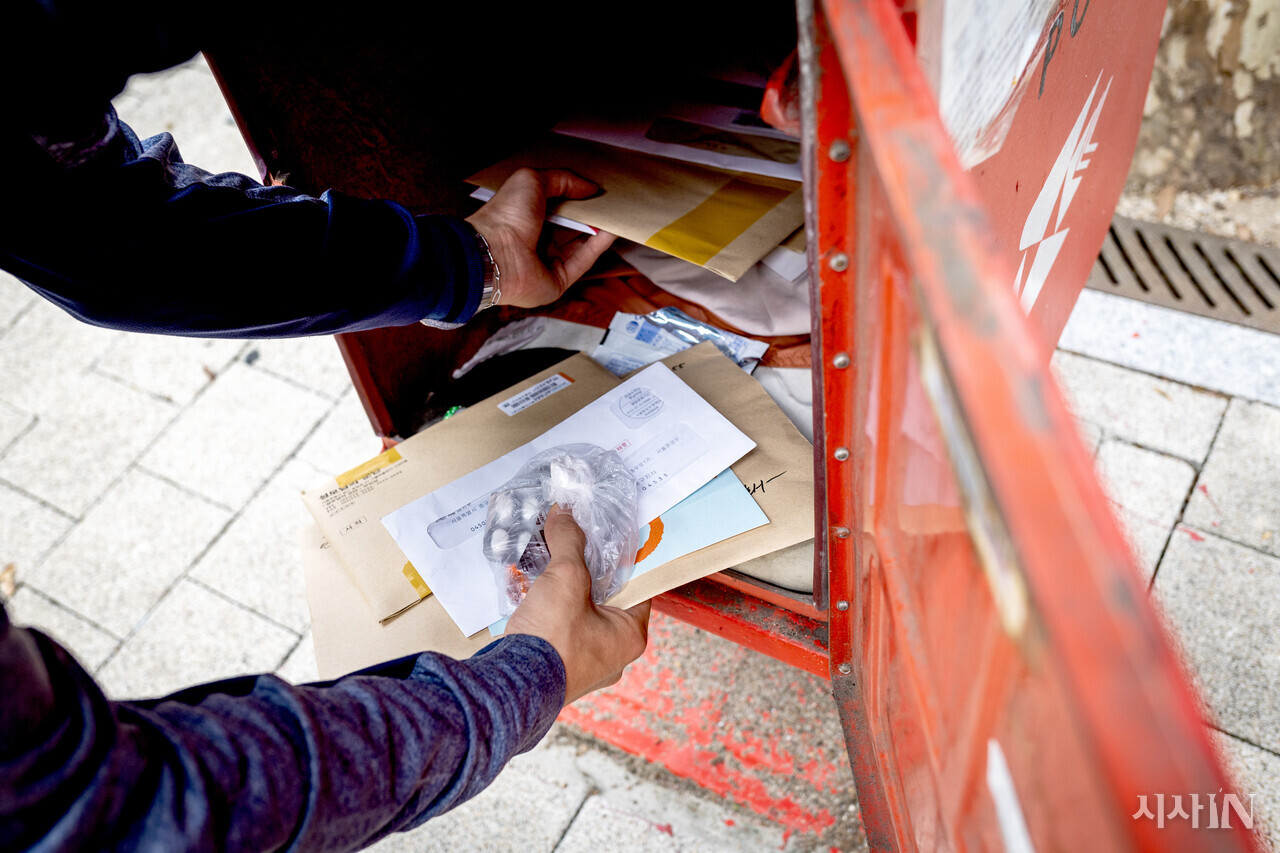 9월8일 서울 중구의 한 우체통에서 백영진 집배원(30)이 우편물과 폐의약품을 수거해가고 있다. 백 집배원은 폐의약품을 소량으로 배출해달라고 당부했다. 대량의 의약품을 넣기에는 배달함의 공간이 작기 때문이다. ⓒ시사IN 박미소