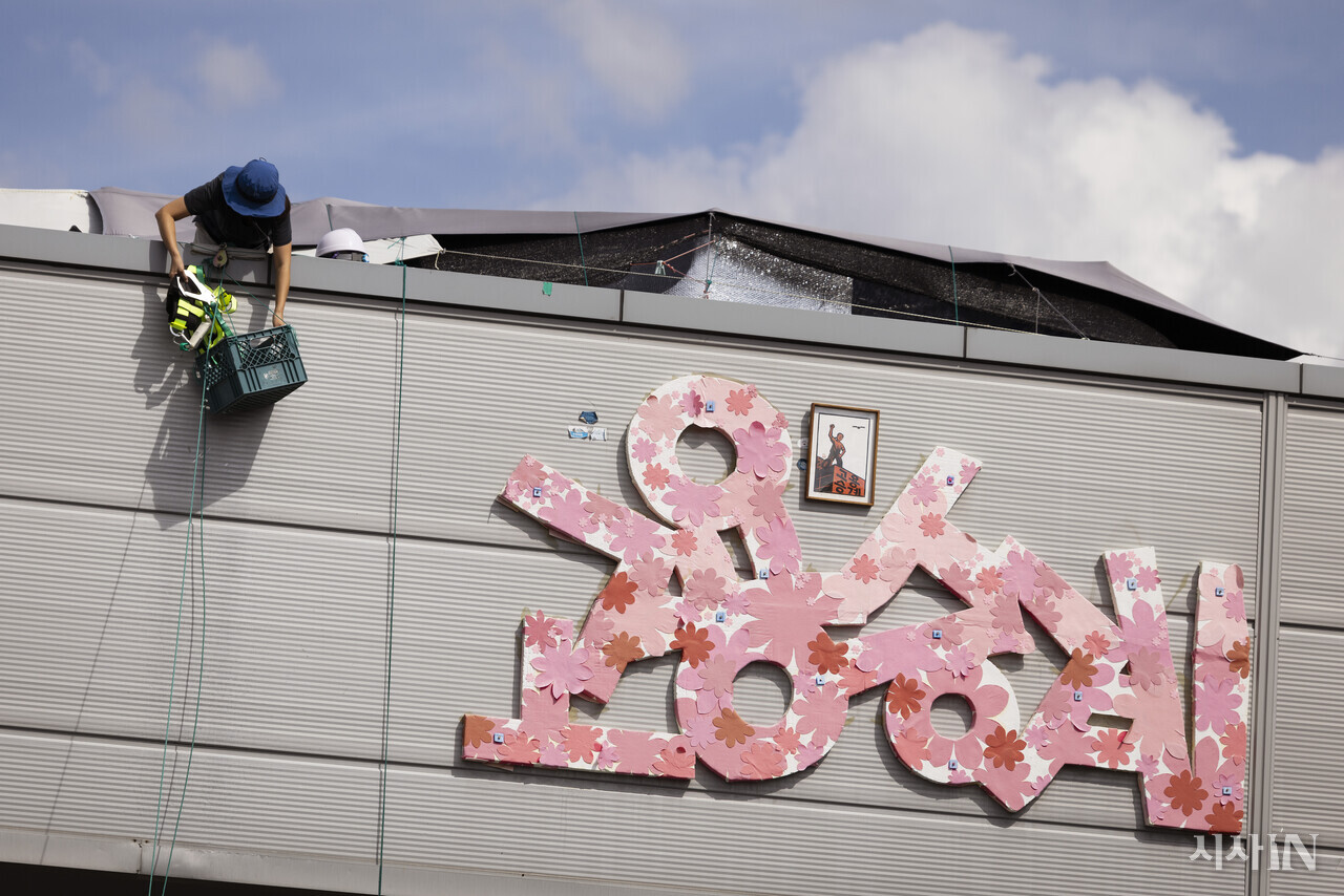 고용승계를 요구하며 600일간 경북 구미시 한국 옵티칼 공장 옥상에서 고공 농성을 벌인 박정혜 금속노조 한국옵티칼하이테크지회 수석부지회장이 8월29일 크레인을 타고 땅으로 내려오기 전 안전띠를 꺼내고 있다. ⓒ시사IN 이명익