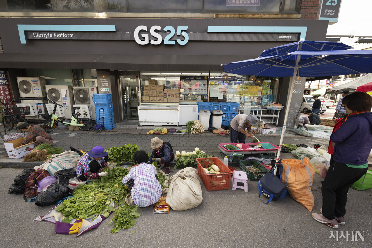 북평오일장의 장터는 북평동의 큰길과 작은 골목 모두를 아우른다. 이른 아침 집에서 키운 열무와 무를 가지고 온 상인들이 편의점 앞에서 손질을 하고 있다. ⓒ시사IN 이명익