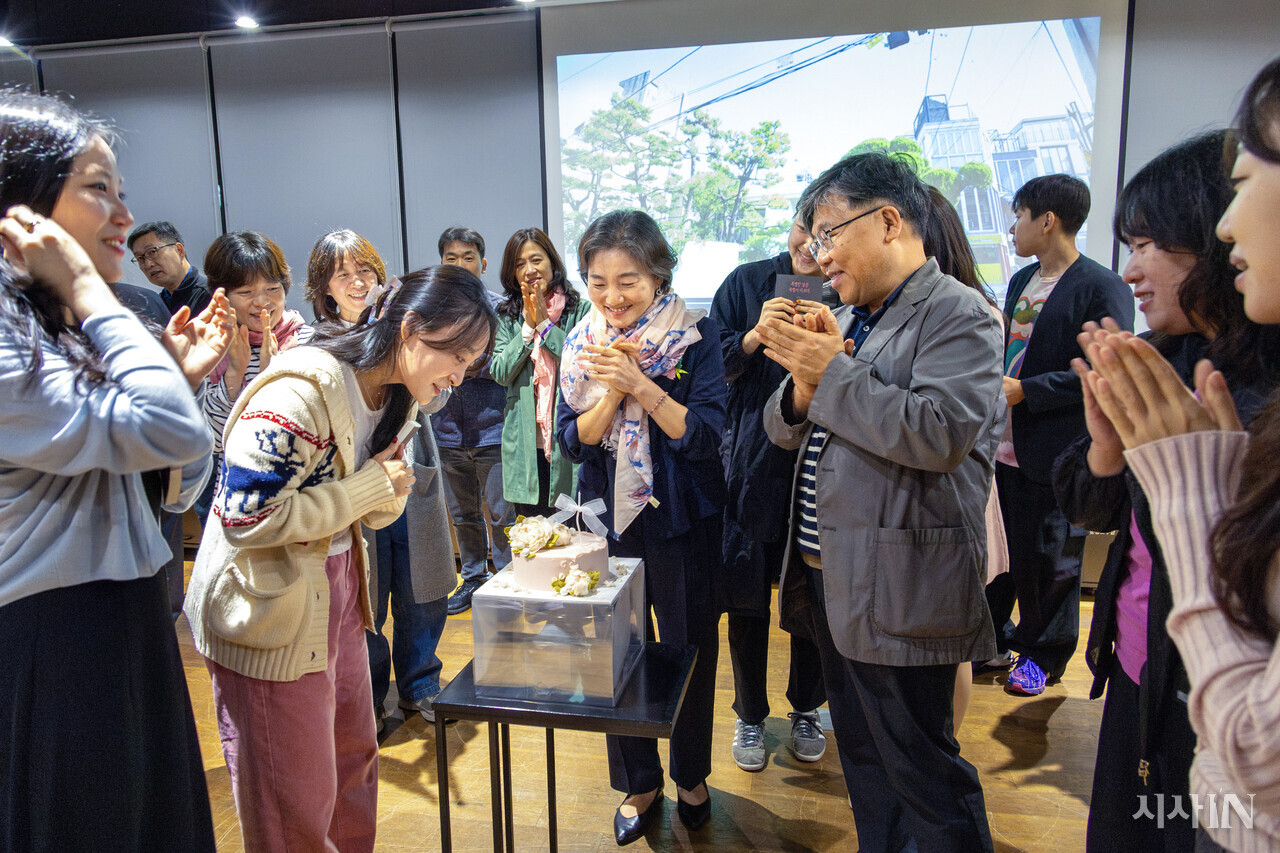 이태원 참사 희생자 고 신애진씨(1998년생)의 생일을 하루 앞둔 10월18일, 서울 성동구의 한 공유 공간에서 열린 생일 모임에서 어머니 김남희씨(가운데)와 아버지 신정섭씨(오른쪽)가 생일 케이크를 바라보고 있다. ⓒ시사IN 박미소