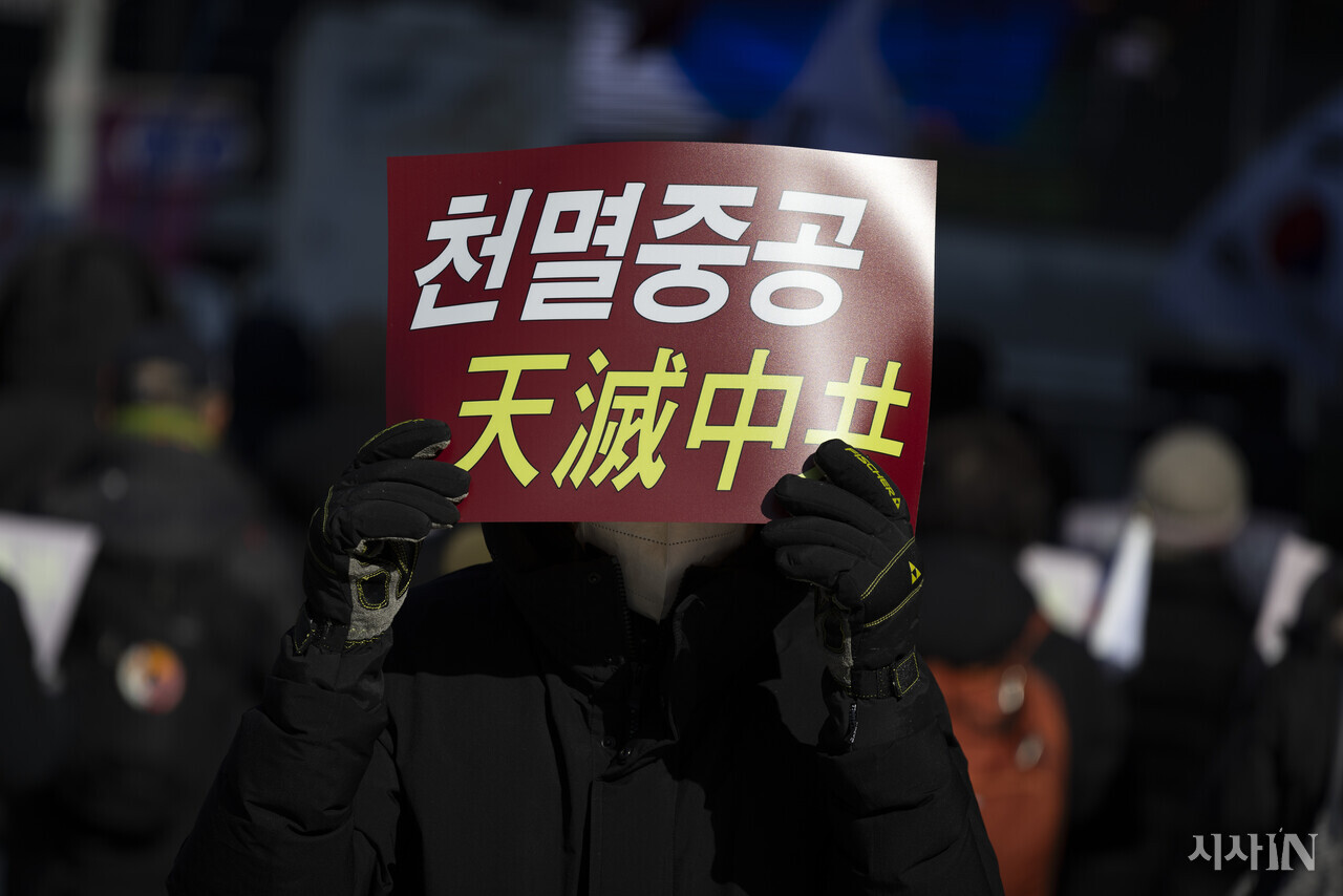 한 보수집회 참가자가 2월6일 서울 중구 서울중앙우체국 앞에서 피켓을 들고 있다. ⓒ시사IN 이명익