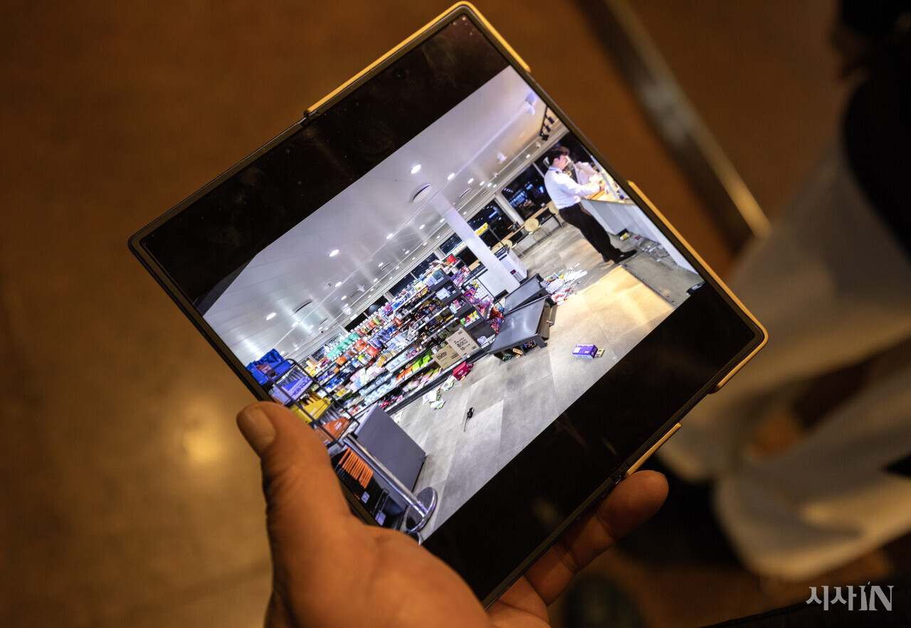 제주도에서 감귤을 실은 화물트럭을 퀸제누비아2호에 선적했던 김모씨가 사고 직후 촬영한 선내 매점 사진을 취재진에게 보여주고 있다. ⓒ시사IN 조남진