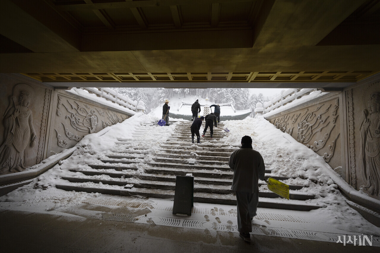 스님들이 월정사의 화엄루 계단에 쌓인 눈을 쓸어내고 있다. ⓒ시사IN 이명익